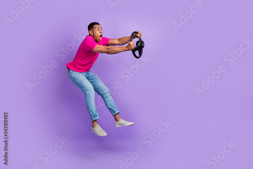 Full size profile photo of impressed person jumping arms hold wheel isolated on violet color background