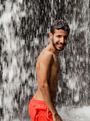 Man standing under a waterfall photo