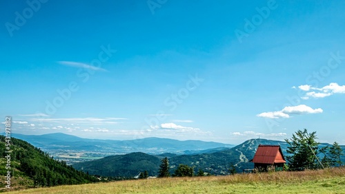Gorgeous view from the top of Klimczok Mountain in southern Poland with a cabin under a bright sky photo
