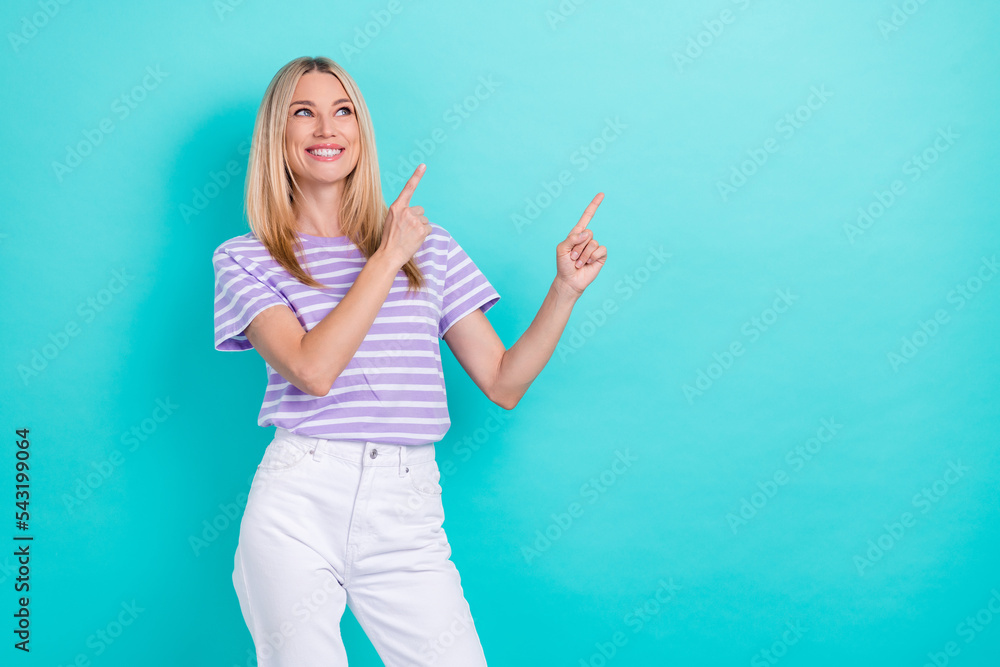 Photo of pleasant gorgeous woman with straight hairdo wear striped t-shirt look indicating empty space isolated on blue color background Photo of pleasant gorgeous woman with straight hairdo wear striped t-shirt look indicating empty space isolated on blue color background