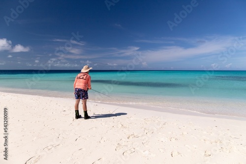 Man fishing in the clear water in White Sand Beach Venezuela Los Roques