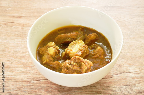spicy boiled pork bone with curry and basil leaf on bowl