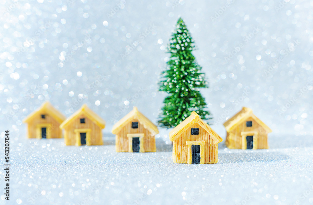 Miniature wooden cottages by a toy Christmas tree