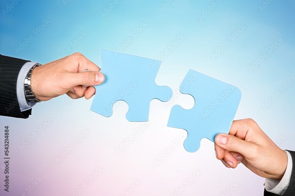 Human hands hold a puzzle piece for teamwork concept Human hands hold a puzzle piece for teamwork concept