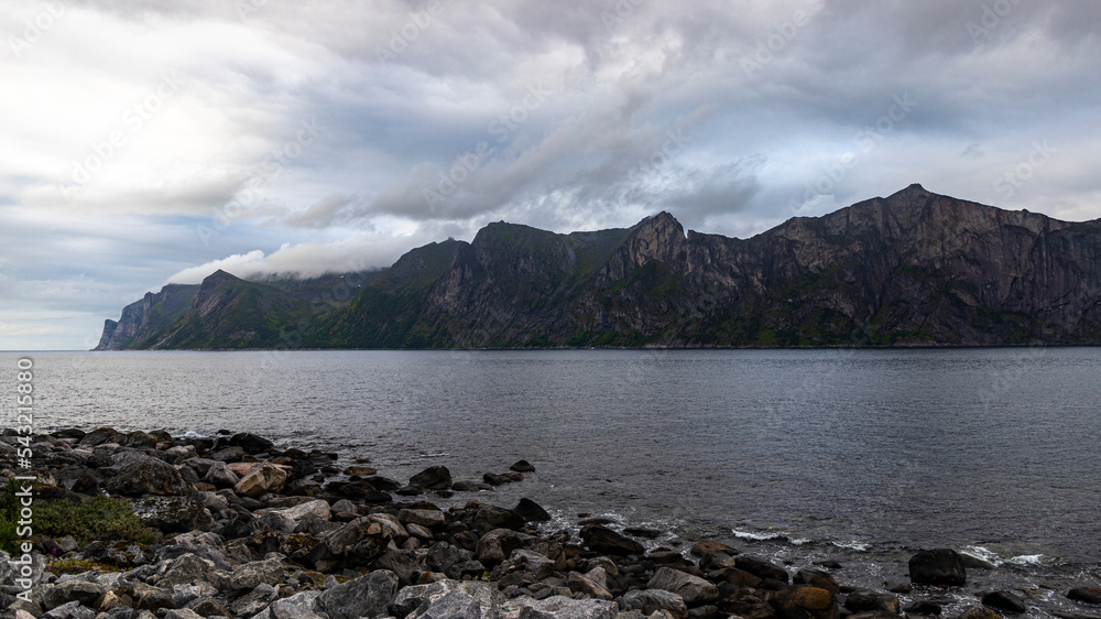 gloomy landscape of the island of senja in northern norway; panorama of the island of senja, the norwegian fjords with their mighty rugged peaks rising out of the sea