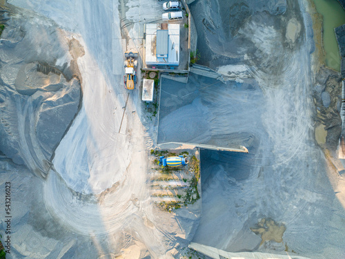 Aerial view of industry plant in sand and gravel mine. Heavy machinery in pit: Dumper Truck and wheel loader.