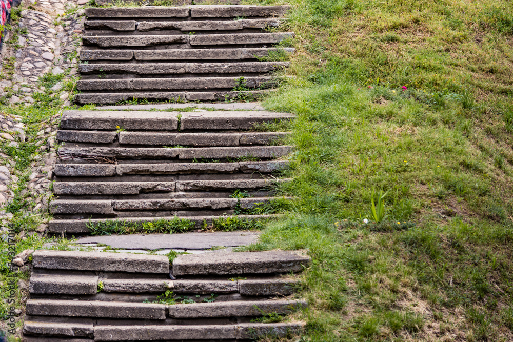 Old concrete stairs with cracks next to a grass hill Old concrete stairs with cracks next to a grass hill