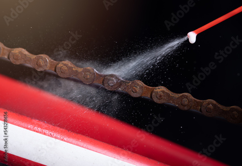 Fotografie Cleaning and oiling a bicycle chain with oil spray.