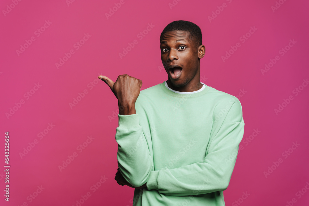 Black young man expressing surprise and pointing finger aside Black young man expressing surprise and pointing finger aside