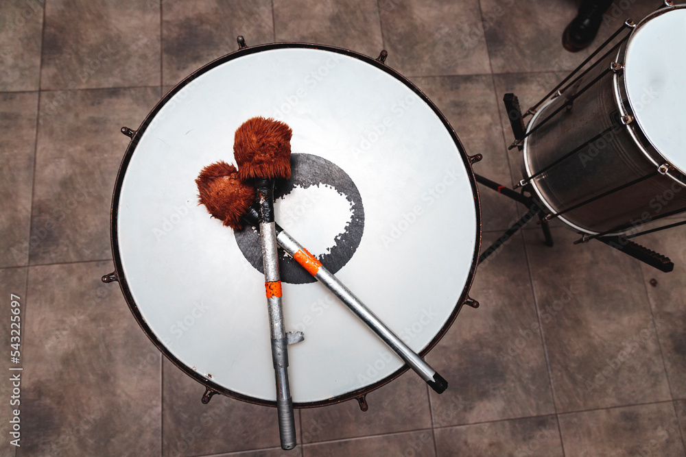 percussion mallets resting on a drum head in an interior