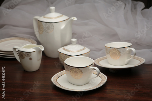 White tea set on a white background. Teapot, cups, plates