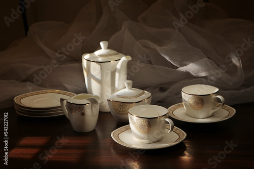 White tea set on a white background. Teapot  cups  plates