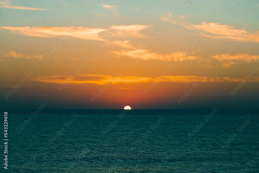 Seascape in early morning, sunrise over sea. Nature landscape. sunshine over the horizon with blue cloudy sky