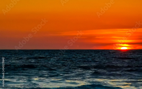 Colorful golden sunset big wave and beach Puerto Escondido Mexico.