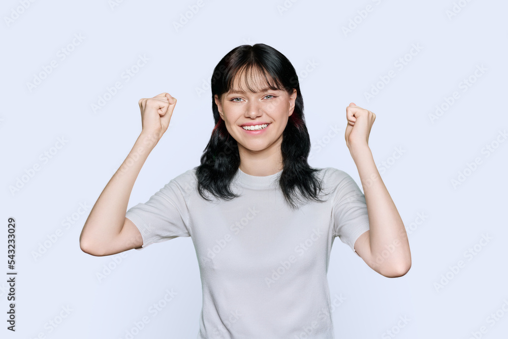 Young happy woman holding fists up, on white background Young happy woman holding fists up, on white background