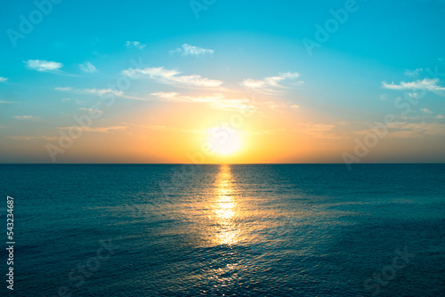 Seascape in early morning, sunrise over sea. Nature landscape. sunshine over the horizon with blue cloudy sky