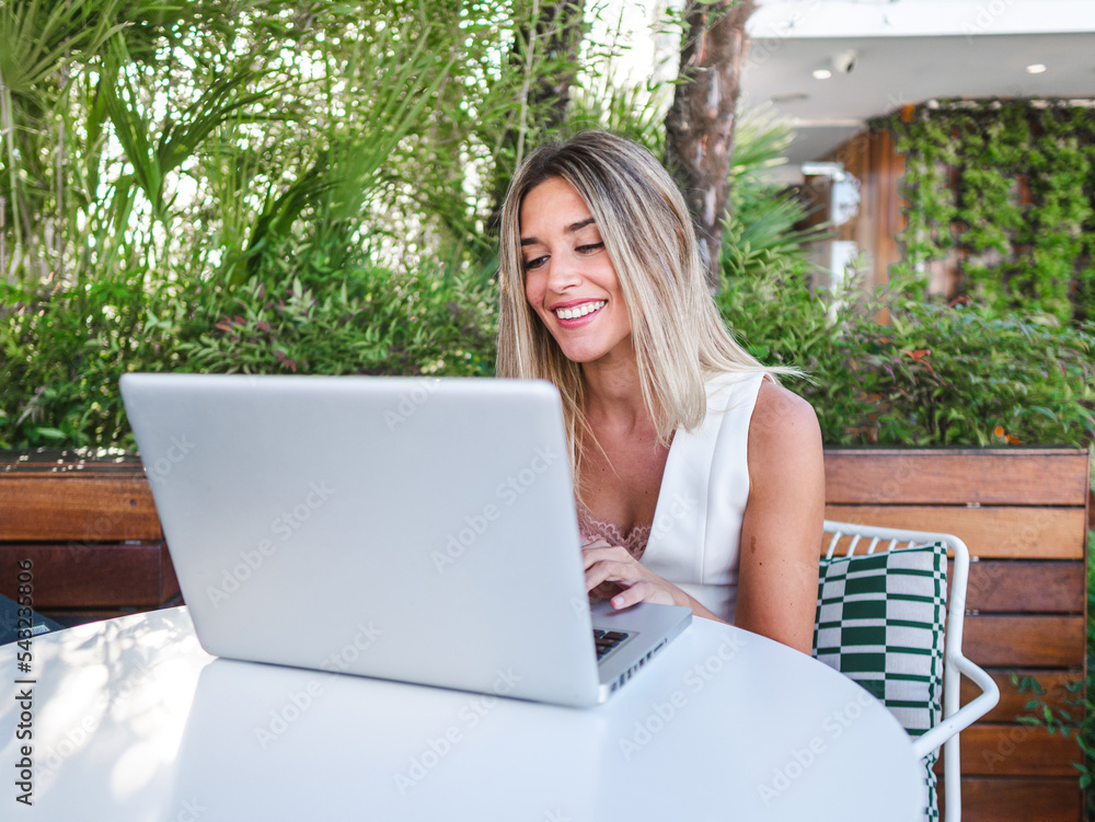 Cheerful female freelancer using laptop on terrace Cheerful female freelancer using laptop on terrace