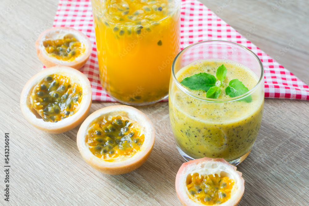 Passion fruit smoothie by fresh ingredients with slice passion fruit on wooden table. Passion fruit smoothie by fresh ingredients with slice passion fruit on wooden table.