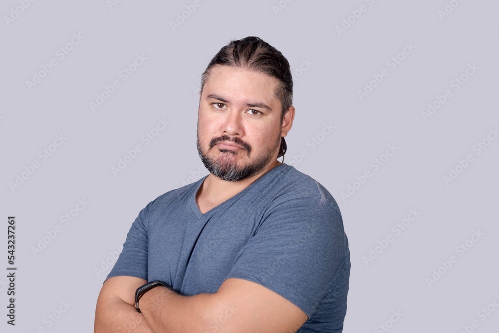 A man in his 30s sulks and frowns, feeling regretful, alone or left out. Looking at camera. Candid scene against a gray background. A man in his 30s sulks and frowns, feeling regretful, alone or left out. Looking at camera. Candid scene against a gray background.