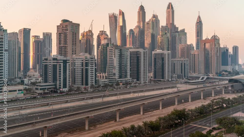 Dubai marina tallest block of skyscrapers timelapse with shadows moving fast during all day. Aerial view from JLT district to apartment buildings, hotels and office towers near highway until sunset Dubai marina tallest block of skyscrapers timelapse with shadows moving fast during all day. Aerial view from JLT district to apartment buildings, hotels and office towers near highway until sunset