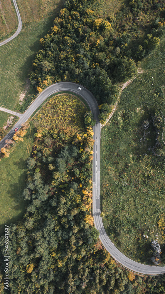 Serpentine roads from top down view. Aerial drone captures highway road in forest. Main communication to next city. Montenegro mountain roads with a lot of curves.
