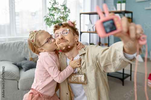 Joyful father and daughter making funny selfie