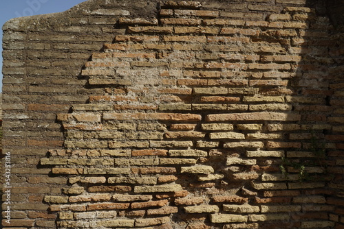Detail of a wall in Roman structure made of bricks and with the opus reticulatum technique in blocks of porphyry, in the archaeological site of Ostia Antica.