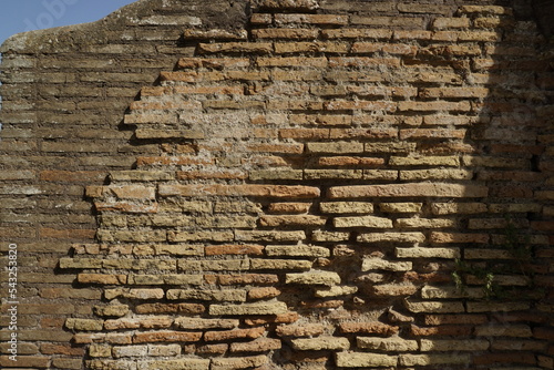 Detail of a wall in Roman structure made of bricks and with the opus reticulatum technique in blocks of porphyry, in the archaeological site of Ostia Antica. photo