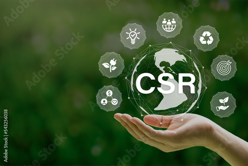 CSR(Corporate social and responsibility) icon concept in the hand for business and organization.Concept to giving back to the community on a green nature background.