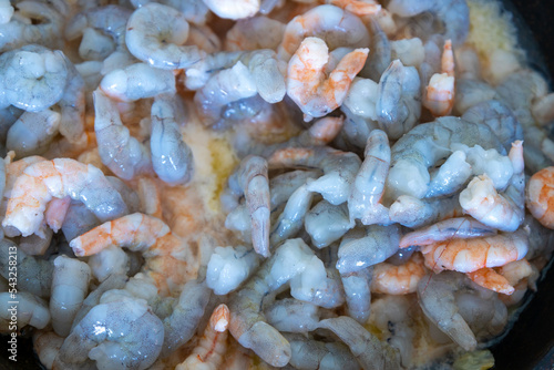 Pink shrimp in the pan as they are cooked for a cocktail.