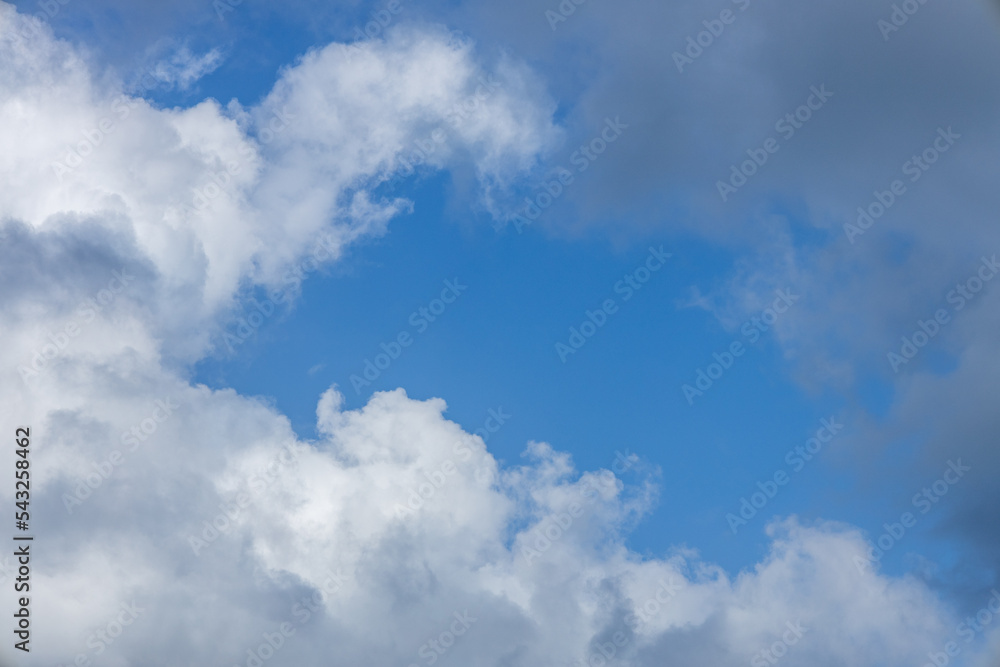 huge white clouds mixed with black clouds in a sunny sky huge white clouds mixed with black clouds in a sunny sky
