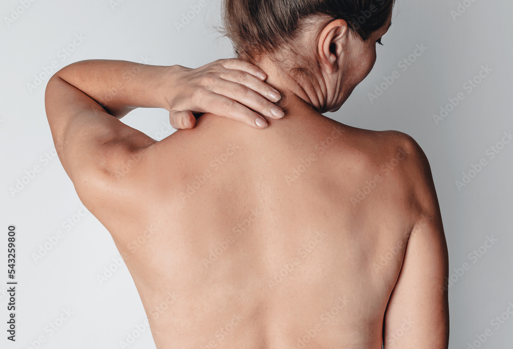 Pain in the neck. Women's neck with pleats. Problems with stooping. Rear view of a middle-aged woman.