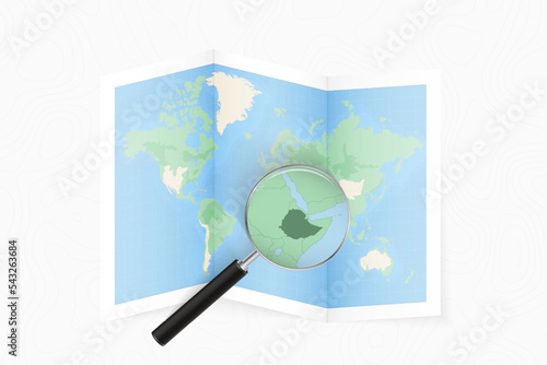 Enlarge Ethiopia with a magnifying glass on a folded map of the world.