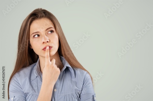 Serious dreaming young woman posing