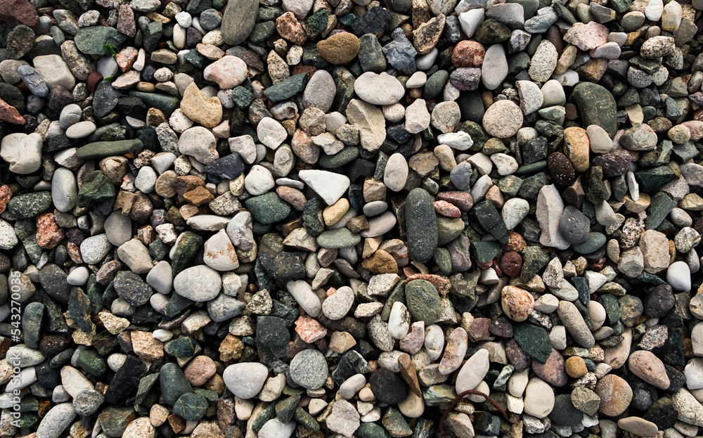 Pattern and texture of small pebbles of different colors in the mountains, texture for a background with soft lighting Pattern and texture of small pebbles of different colors in the mountains, texture for a background with soft lighting