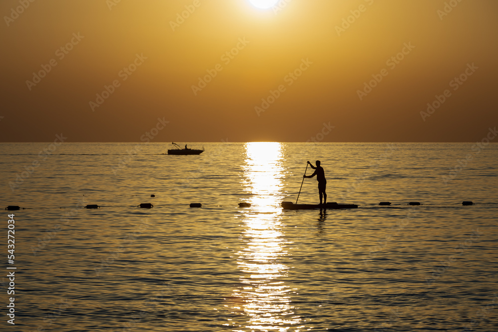 Man on stand up paddleboard at sunset in Turkey ocean
