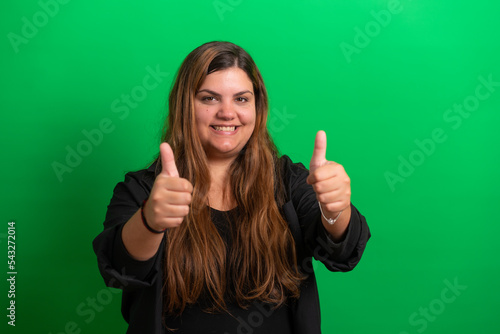 Young woman, wearing black, thumbs up, on  Green Background