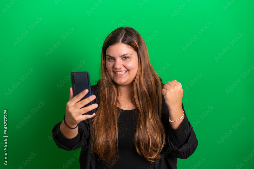 Young woman holding a mobile,  Green Background