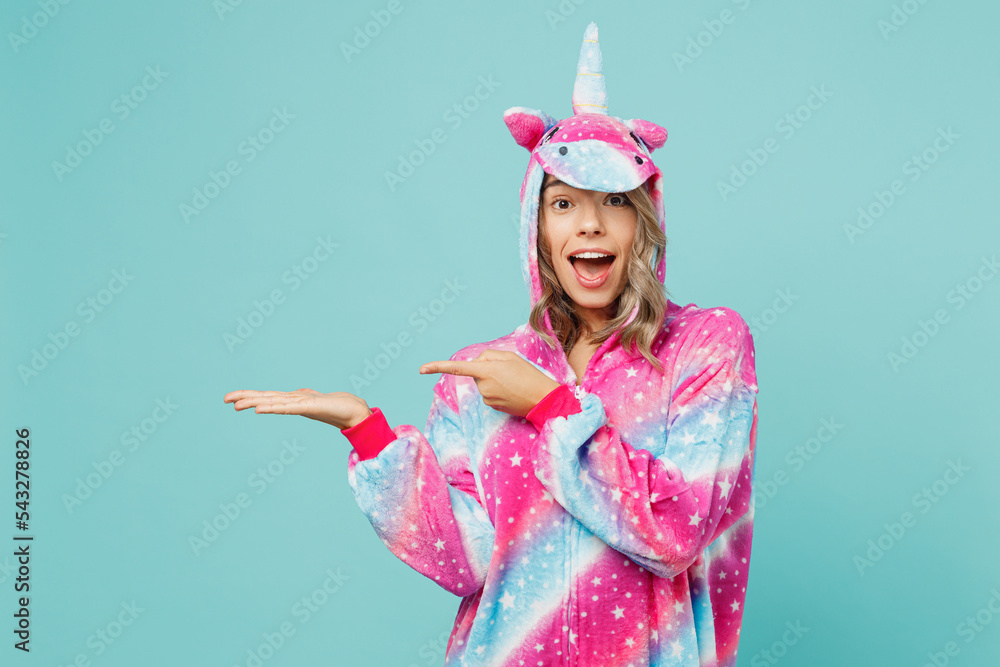 Young woman she wear domestic costume with hoody and animals ears point finger on empty palm with copy space place mock up isolated on plain pastel light blue cyan background People lifestyle concept