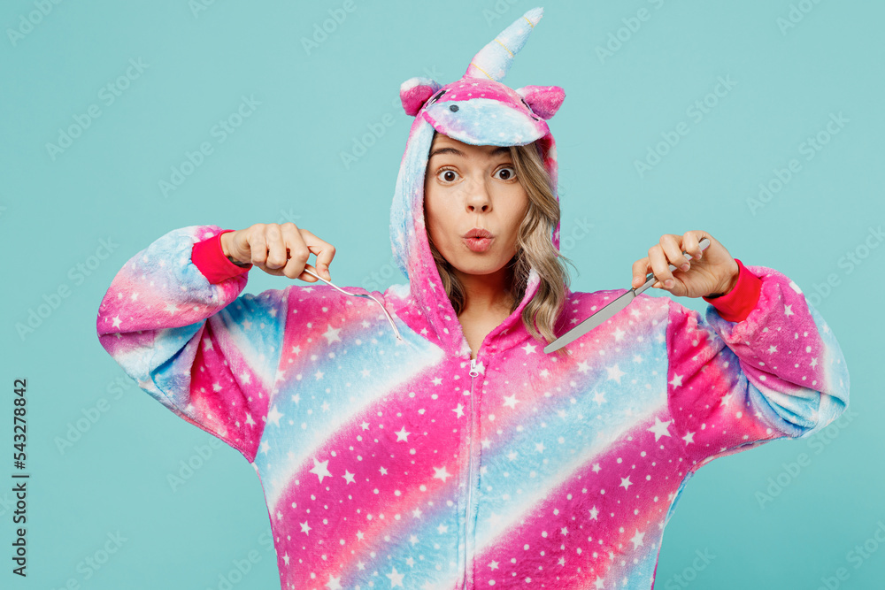 Young astonished woman 20s wear domestic costume with hoody and animals ears hold spoon and fork going to eat late evening isolated on plain pastel light blue cyan background People lifestyle concept