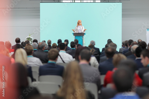 Tableau sur toile Female doctor giving a speech on a pedestal in front of an audience at a congres