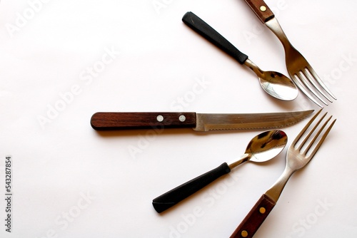 Utensilio de cocina de metal acero inoxidable con cucharas, tenedor y cuchillo en forma de medio abanico, presenta un bonito y muy original diseño culinario con fondo blanco