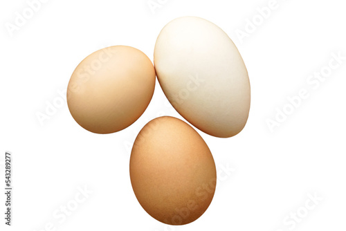 Three chicken eggs of different colors and different sizes lie in a wicker basket