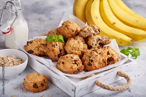 Cookies with oat flakes, bananas and chocolate. Delicious homemade biscuits served with milk. photo