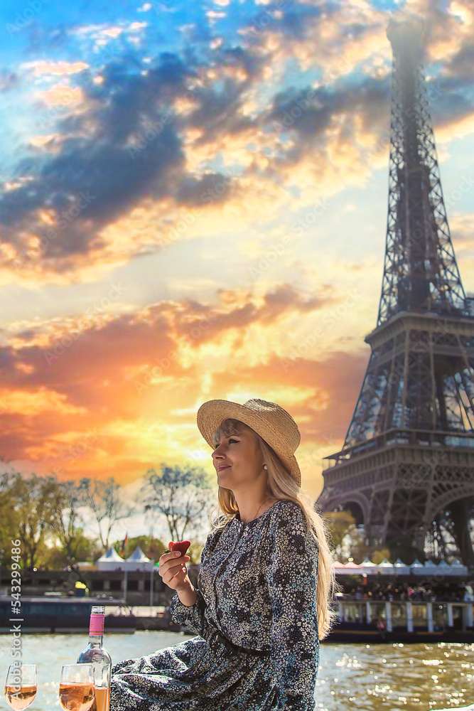 A woman near the Eiffel Tower drinks wine. Selective focus.
