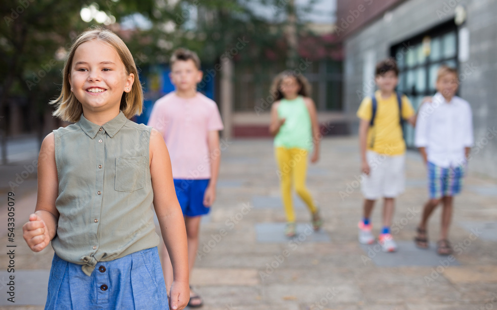 Obraz premium Closeup portrait joyful preteen girl walking along city street on sunny summer day..