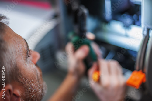 All machines nead maintains. Professional technician troubleshooting and repair the machines in the printing house. photo