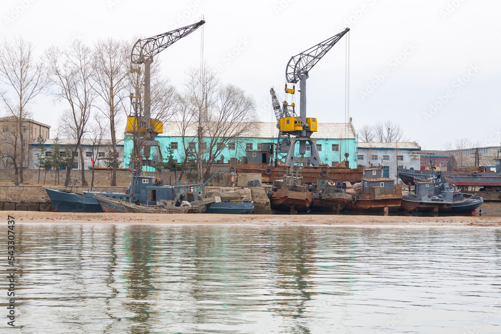 DANDONG, CHINA: boats docked in Sinuiju, North Korean side of Yalu River