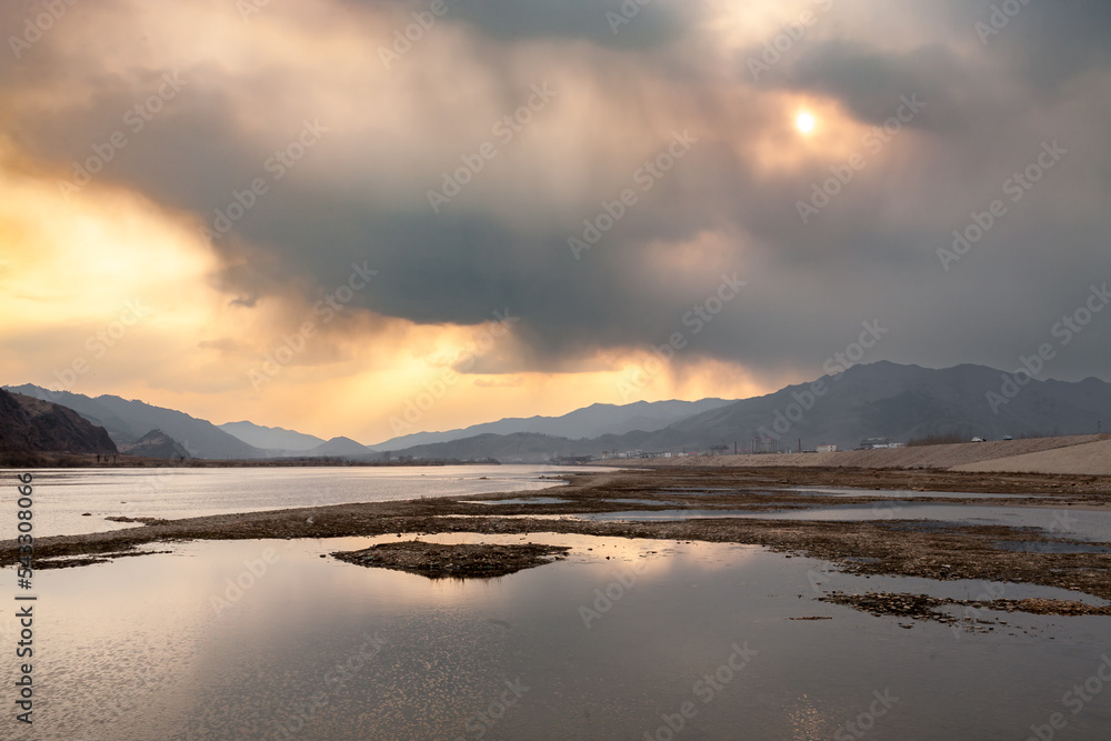 JI'AN, JILIN PROVINCE, CHINA: sunset on Yalu river, sino-korean border, view of countryside and mountains accross the river, in North Korea