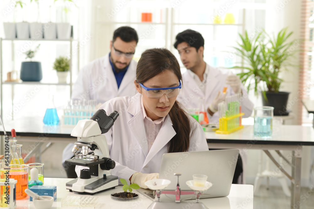 A group of research medical scientists, male and female, working with microscope testing equipment in the laboratory. A professional scientist analyzing biochemical samples on a microscope in a lab. A group of research medical scientists, male and female, working with microscope testing equipment in the laboratory. A professional scientist analyzing biochemical samples on a microscope in a lab.
